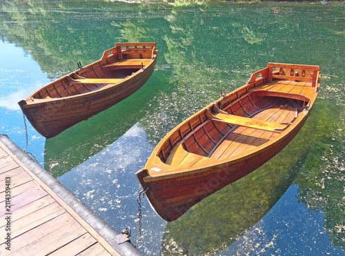 Принти на полотні A wooden boat dock with two orange wooden pleasure boats on Lake Skadar in Monte