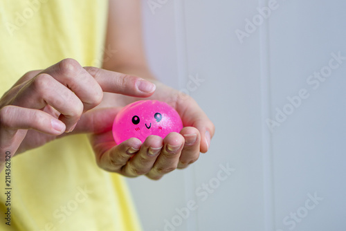 Hands present a pink squishy sensory toy before tactile play in close-up. Concept of stress relief, emotional regulation, calming activity and mindfulness.