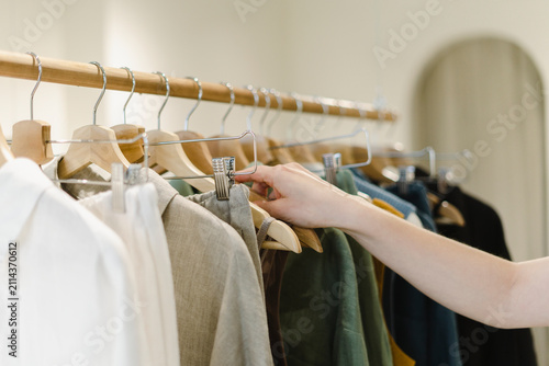 Hand of woman on coathanger at store