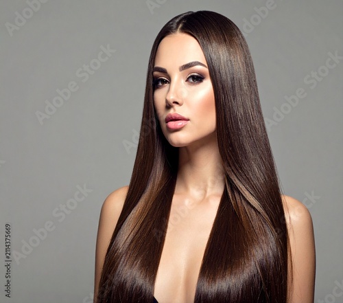 Beauty portrait of a young brunette woman with long straight dark hair posing in studio.