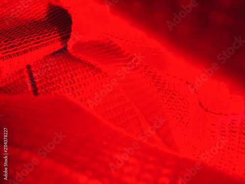 Dramatic red light reflection casting vibrant glows on luxurious textured fabric. A bold, moody abstract background perfect for high-end fashion branding, creative advertising