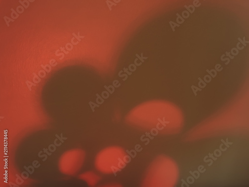 Abstract moody background featuring organic plant shadows cast on a textured vibrant red wall. Ideal for contemporary art overlays, minimalist cosmetic branding, and bold graphic design backdrops.