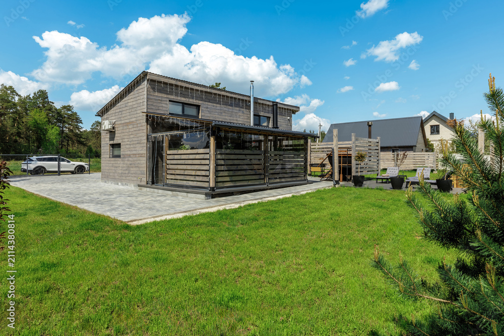 Obraz premium Modern Country House Exterior with Paved Yard and Lawn
