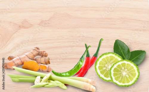 Fotografía Fresh turmeric, lemongrass, kaffir lime, and red chili on rustic wood, top view,