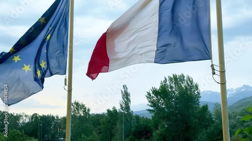 French and European Union flags waving against the Alps