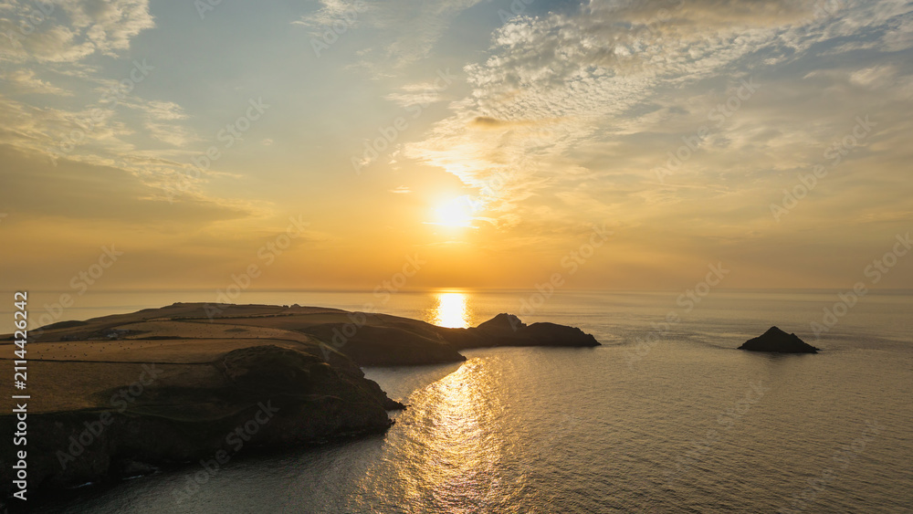 Fototapeta premium Beautiful drone landscape image of Pentire Headland and The Rumps in Cornwall and surrounding countryside during colorful Summer sunset