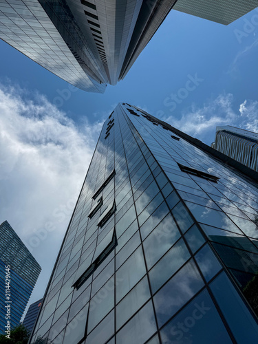 Glass office towers reflecting clear blue sky.