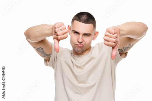 Upset unsatisfied man showing thumbs down with on white background