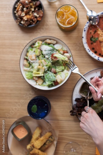 Konstfotografi A hand elegantly reaches for a bite of fresh salad, surrounded by an array of de