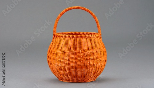 A bright orange woven wicker basket with a sturdy round handle