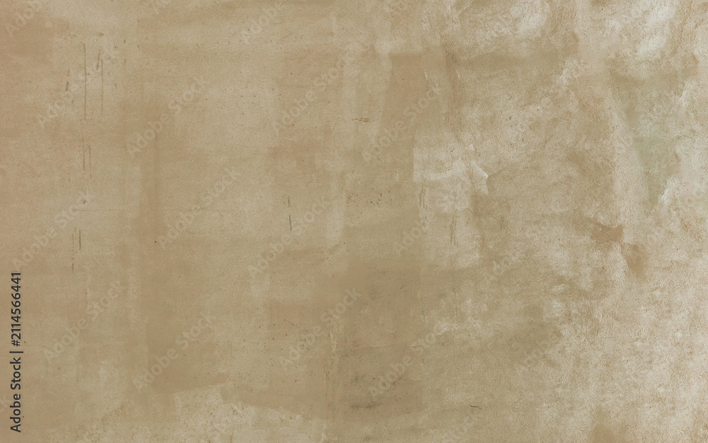 Fototapeta premium Warm beige sand stucco wall background defined by a subtle neutral texture, organic paint smudges, and faint traces of wear, serving as a versatile canvas for minimalist designs.