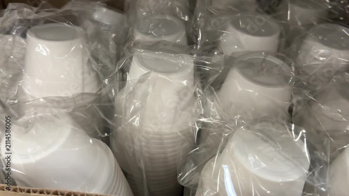 Packed white disposable containers are arranged for sale in a large retail store, providing practical packaging for food storage, takeaway meals, catering and convenient everyday use. Close up.