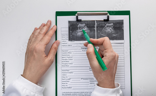 Doctor reviewing abdominal ultrasound images with patient medical records. Diagnostic imaging and clinical examination.