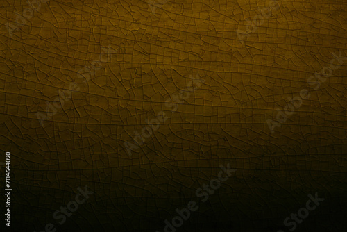 Abstract background of detailed golden cracked glaze pattern on vintage ceramic surface, featuring rich yellow ochre tones, intricate mesh texture, dark shadows, and an elegant aged antique feel.