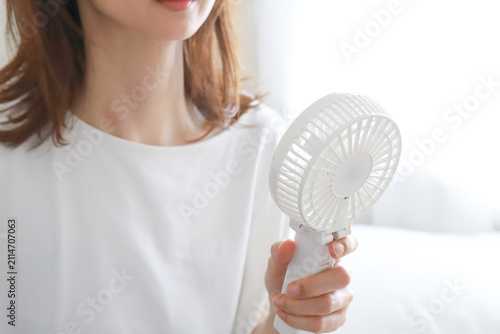 ハンディファンを使う女性の手元　暑さ対策
