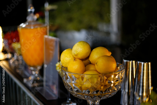 Crystal bowl filled with fresh yellow lemons for table and bar decoration