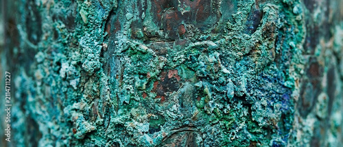Aged weathered copper metal surface with thick green patina crust