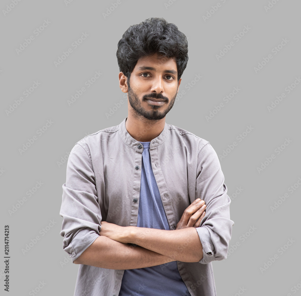 Obraz premium Portrait of handsome smiling young man with folded arms. Laughing joyful cheerful men with crossed hands studio shot. Isolated on gray background