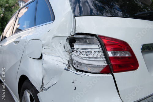 White car after crash accident. Broken taillight and bumper. Rear horizontal view.