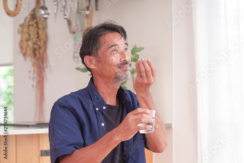 内服薬を飲もうとするシニア男性