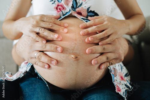 Фотография Hands gently cradling a pregnant belly