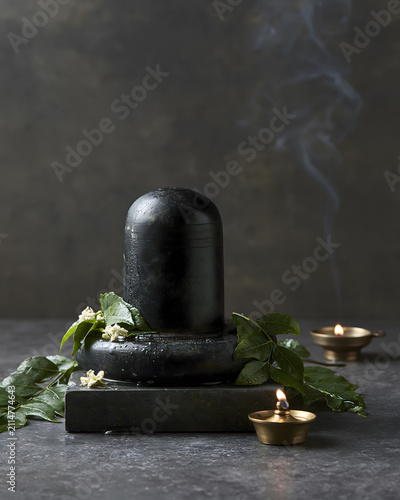 Sacred Shiva Lingam with Bilva Leaves Brass Diyas and Incense Smoke