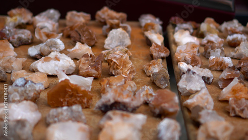 Принти на полотні Authentic tourist souvenirs featuring unique raw mineral stones and crystals with beautiful crystalline texture arranged on a rustic wooden counter under soft natural light