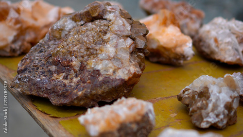 фотографія Authentic tourist souvenirs featuring unique raw mineral stones and crystals with beautiful crystalline texture arranged on a rustic wooden counter under soft natural light