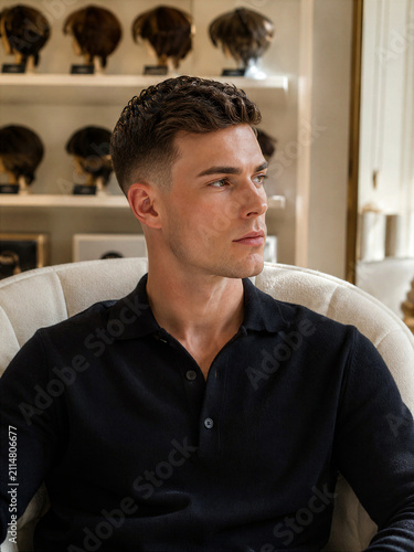 Man sitting in a chair, looking thoughtfully to the side