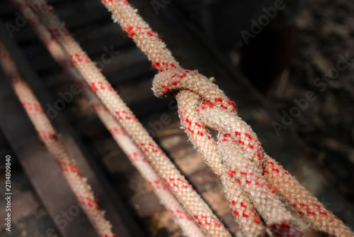 Foto Worn climbing rope with red tracers tied with simple knot, close up detail showi