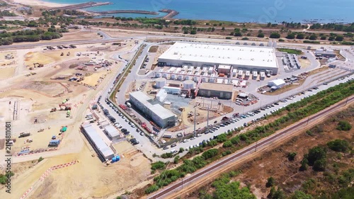 Data center building and expansion site under construction near the coastline in Portugal. Atlantic ocean. Aerial view. Moving sideways
