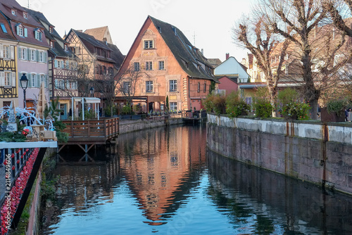 Half-timbered houses reflecting on a canal in Colmar, France.