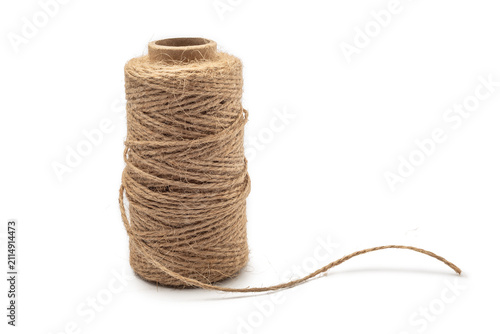 Spool of natural jute twine with loose end, isolated on white background. Material for rustic crafts