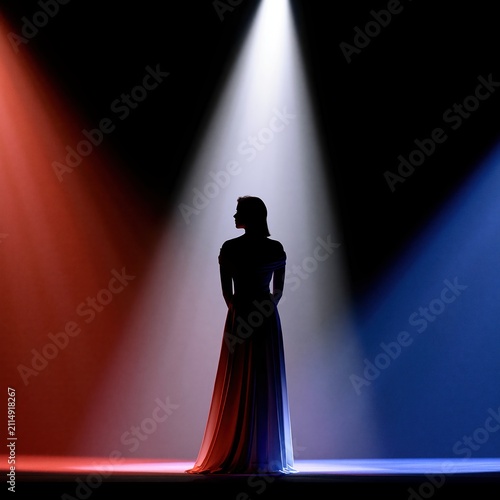 Silhouette woman standing stage spotlight red blue