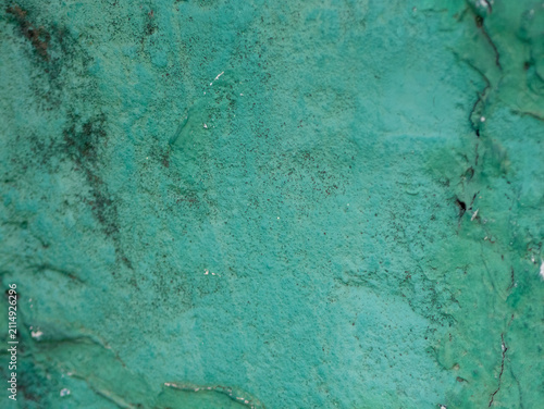 Close-up of a weathered, textured turquoise wall surface with peeling paint, cracks, and vintage patina, Gamcheon Culture Village Busan.
