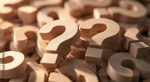 Pile of wooden question mark symbols creating a textured, warm, abstract background