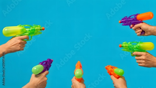 Hands holding colorful water guns ready for play