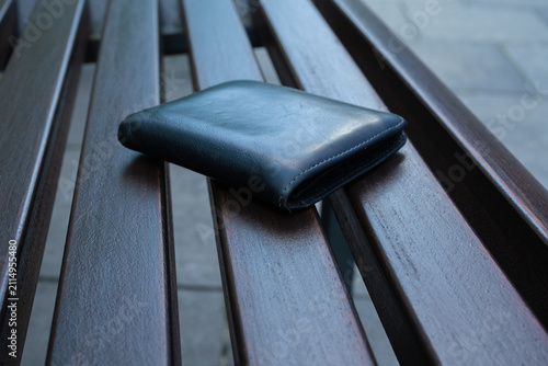 The lost wallet on the street, forgotten black leather object