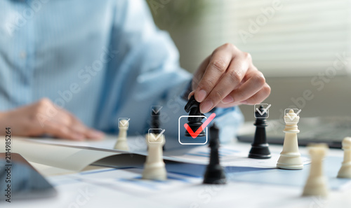 Fotografía Business hand moving chess piece with approval check icons over financial documents, representing strategic planning, decision making, leadership, business success, management and risk assessment