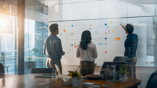 Business team mapping abstract strategy roadmap on large office whiteboard