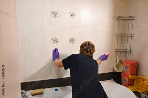 Obraz na płótnie Woman cleaning tiles in a bathroom during daylight