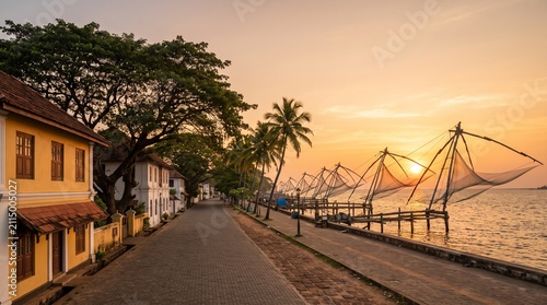 Picturesque sunset over the tranquil backwaters of Fort Kochi, India, showcasing traditional Chinese fishing nets and historic colonial architecture.