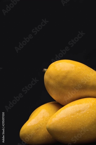 Fresh yellow mangos against a dark background