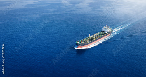 Aerial view of a crude oil or chemical goods tanker sailing with speed over calm ocean with copy space as a banner