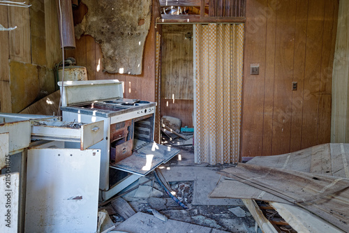 Canvastavla Sunlight through holes in the roof casts spots of light on the kitchen of an aba