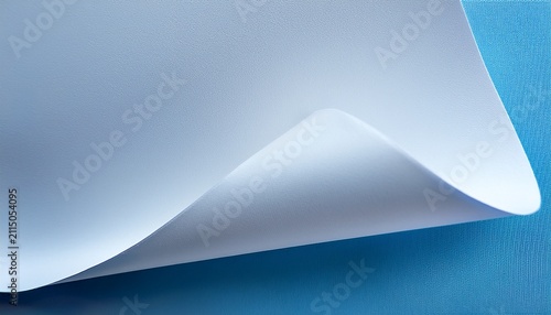 a close up image of a curled textured white paper sheet against a soft blue background