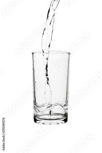 Konstfotografi Fresh water pouring into a clear drinking glass isolated on a white background
