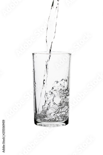 Obraz na plátně Pouring fresh drinking water into a clear glass isolated on a white background