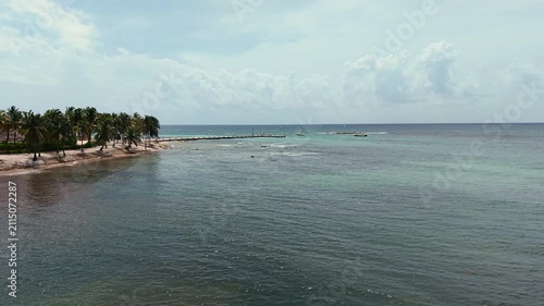 Aerial view of green Caribbean sea ,sandy beach, pier with docked boats and palm trees in Playa del Carmen, Cancun, Mexico
