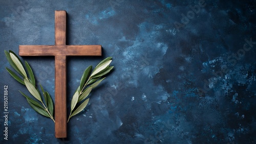 Wooden christian cross with olive branches on blue background symbolizing faith hope and spirituality